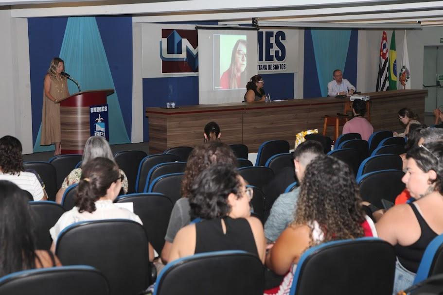 pessoas sentadas em auditório assistindo palestra. #paratodosverem 