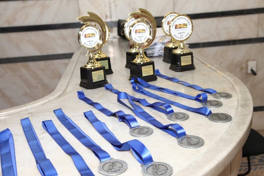 medalhas e troféus sobre uma mesa. #paratodosverem 