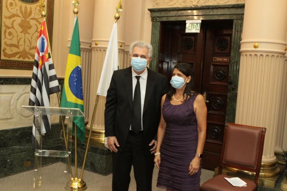 Alvaro Norberto e Ana Beatriz posampara foto em frente às bandeiras do Estado de São Paulo, do Brasil e de Santos. #paratodosverem