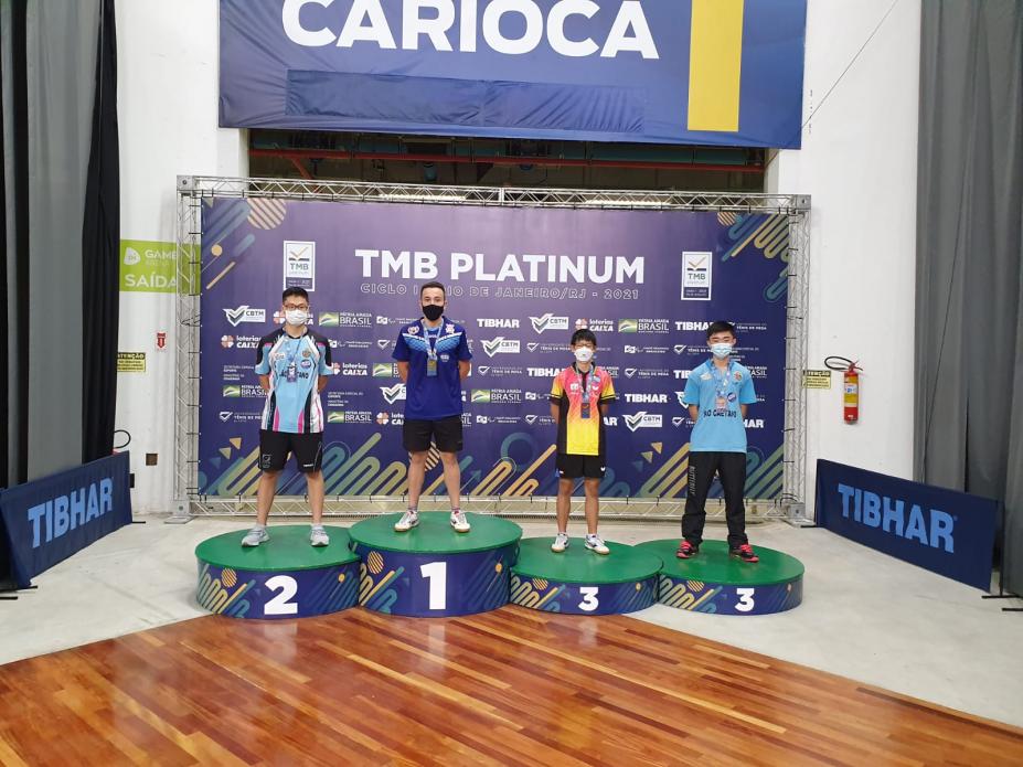 Atleta Richard Pinheiro no lugar mais alto do pódio, com outros três atletas ao lado. #pracegover