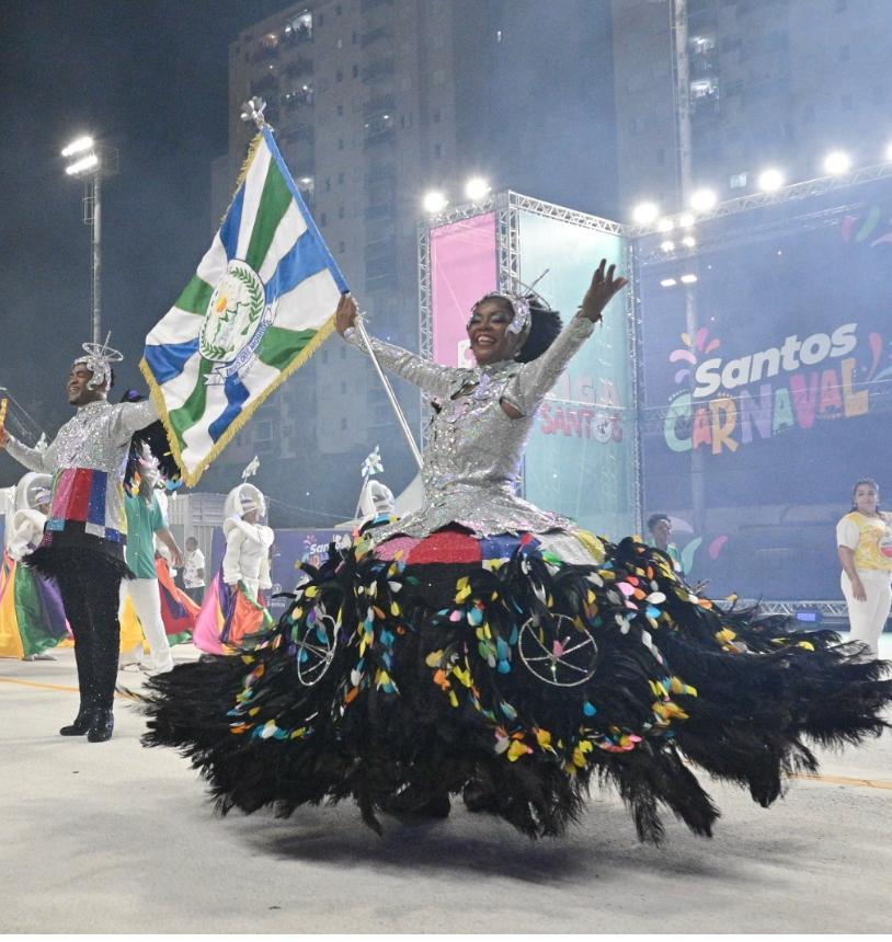 porta-bandeira e mestre sala desfilando. #paratodosverem
