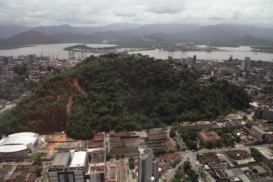 Vista geral de morros em Santos, com o mar ao fundo e a cidade em torno. #paratodosverem