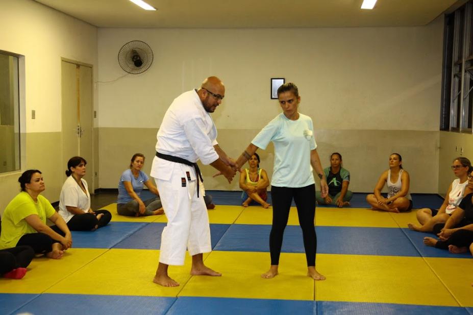 Professor ensina técnica para mulher com outros mulheres assistindo #paratodosverem