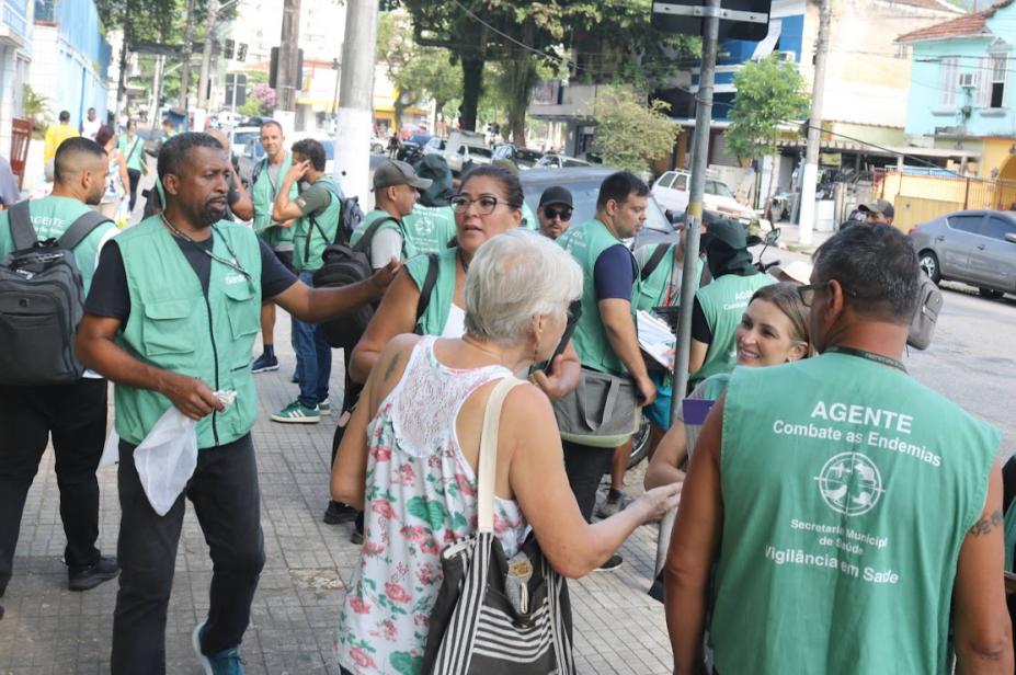 pessoas em contato com agentes na rua #paratodosverem