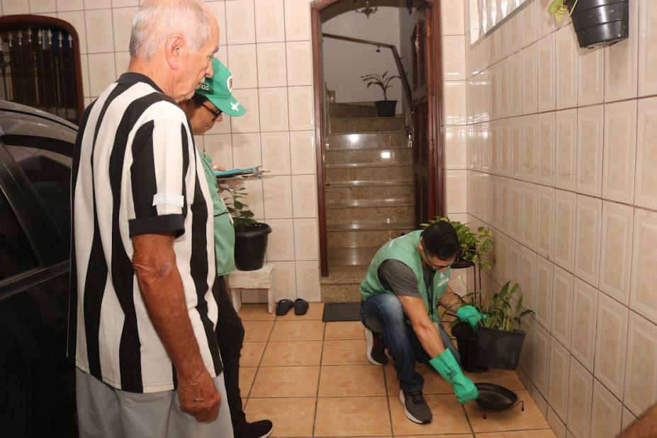 agente faz vistoria enquanto morador observa #paratodosverem 