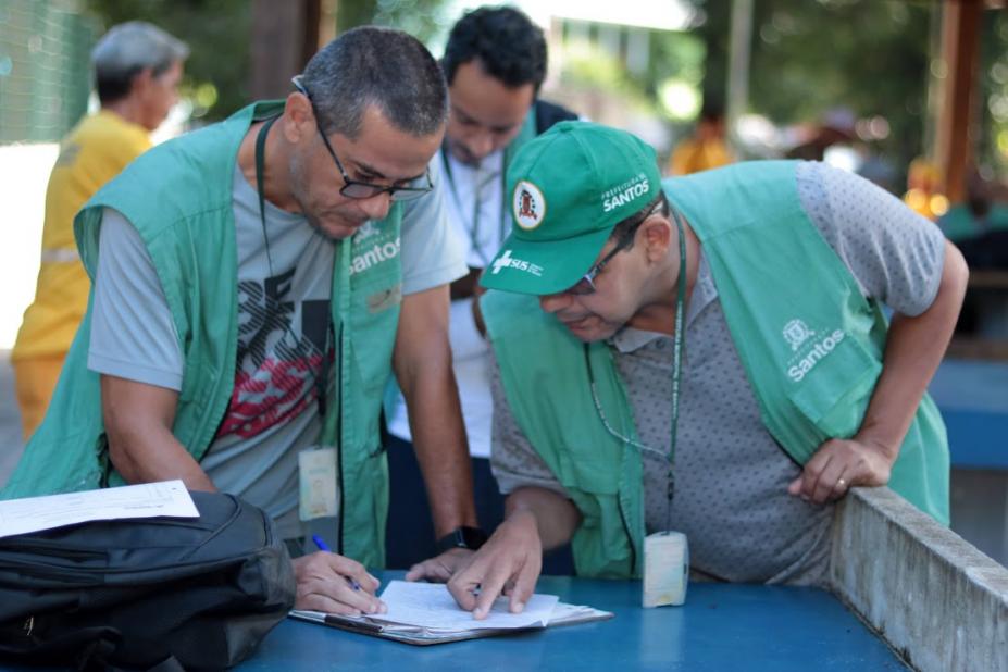 agentes olham papel em mesa #paratodosverem