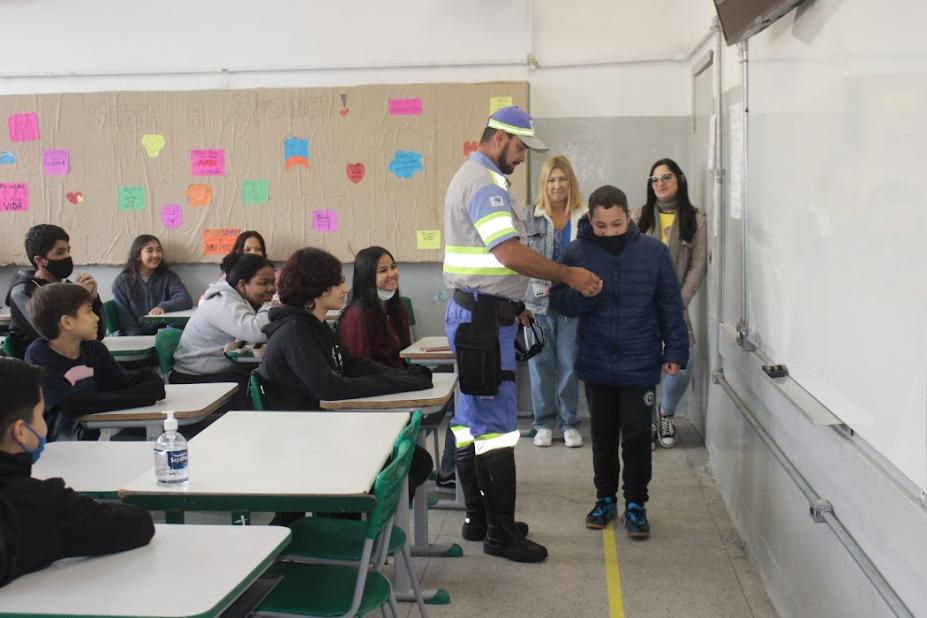 na sala de aula, agente segura aluno em demonstração #paratodosverem