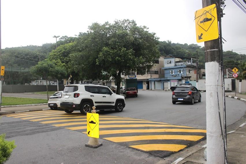 lombada em avenida com canteiro central ao lado esquerdo e poste ao direito. 