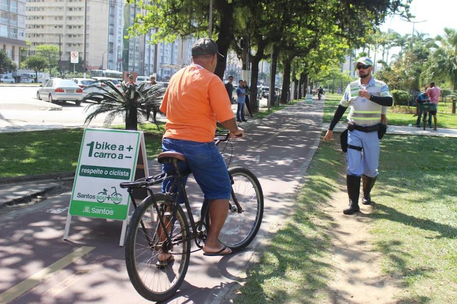 ciclista para na ciclovia ao lado de placa com agente da cet mais a frente #paratodosverem