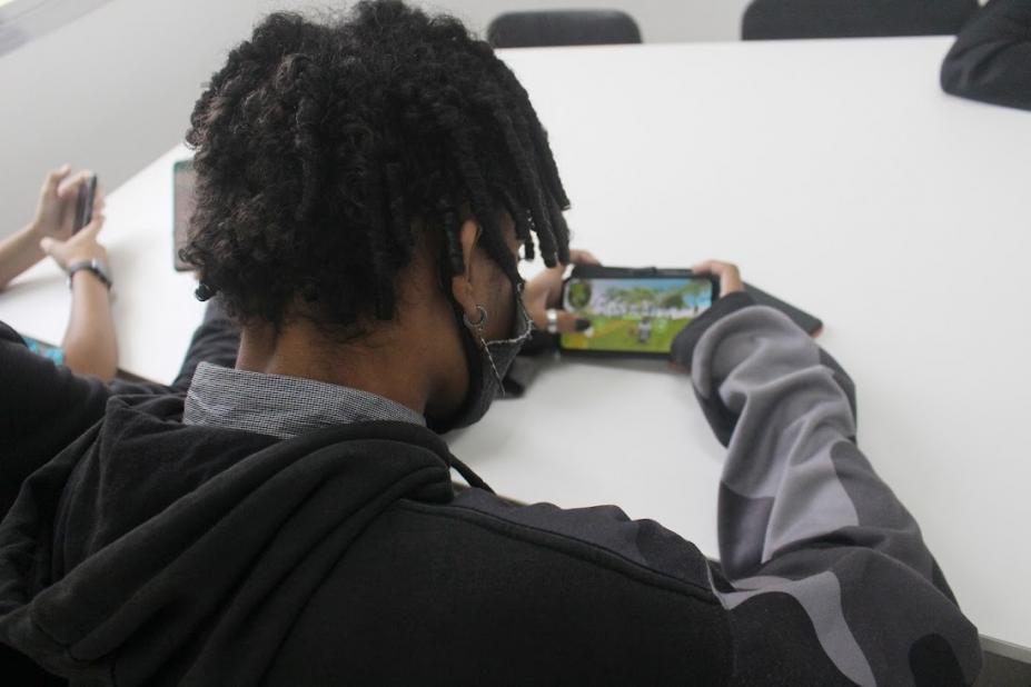 estudante jogando game no celular #paratodosverem