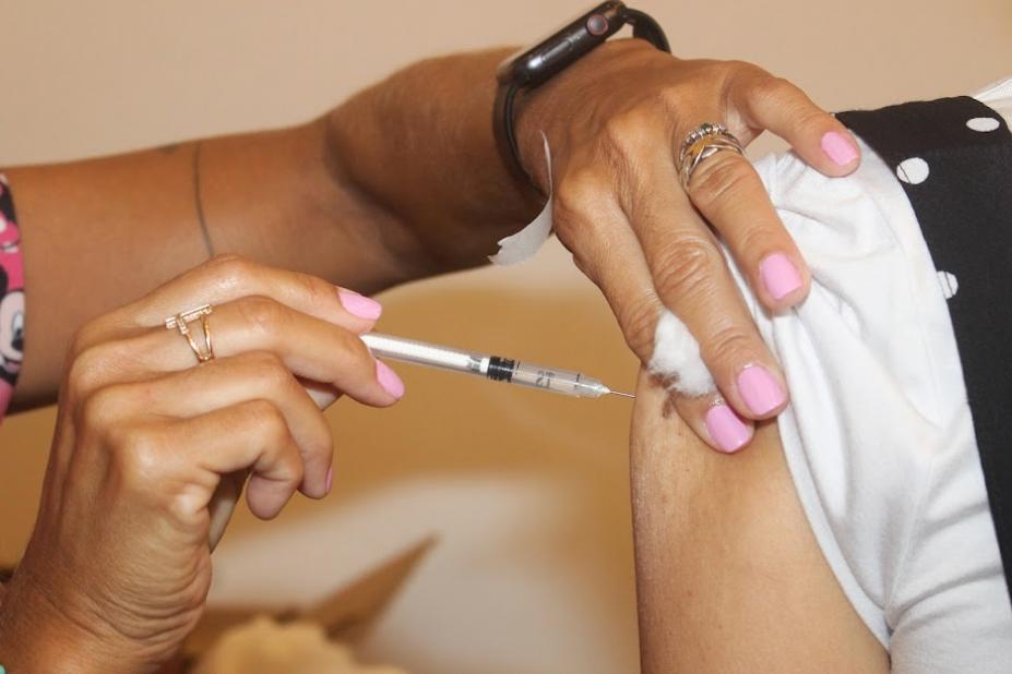 mãos de mulher vacinam um braço. #paratodosverem