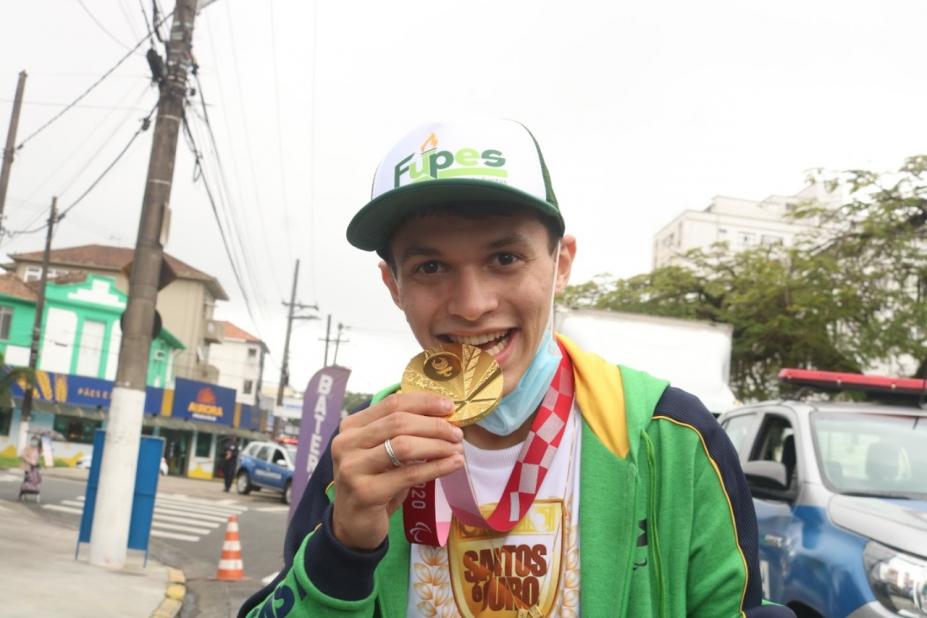 atleta mordendo a medalha de ouro #paratodosverem