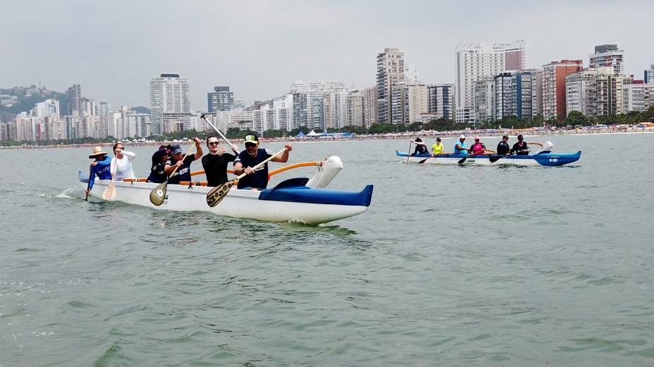 duas embarcações com seis remadores em cada está no mar. #paratodosverem