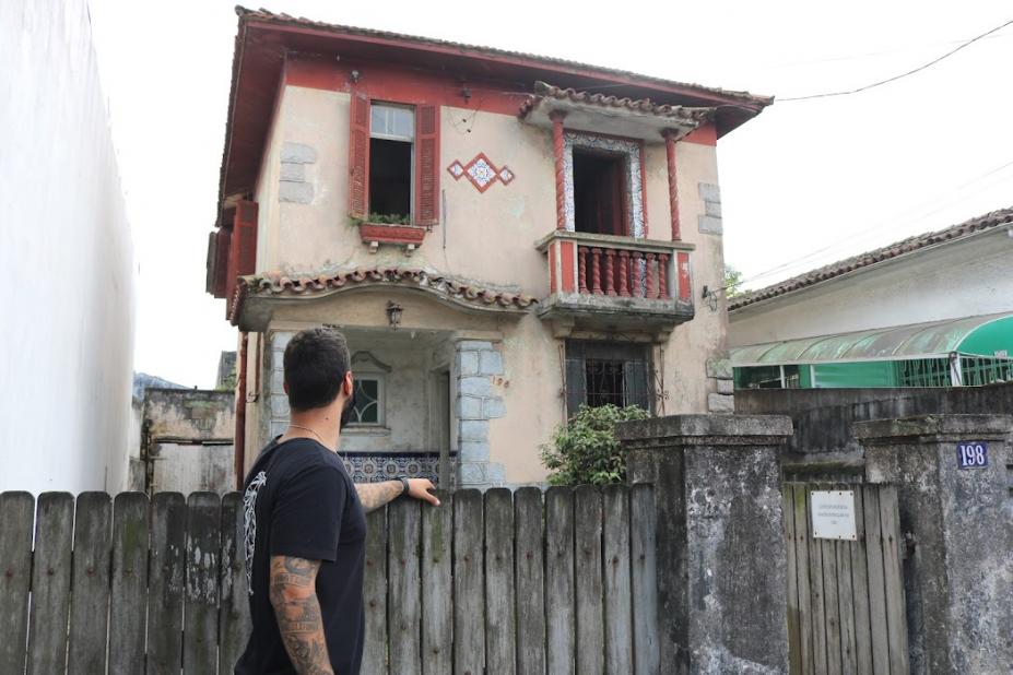 Homem olha para casa antiga #paratodosverem