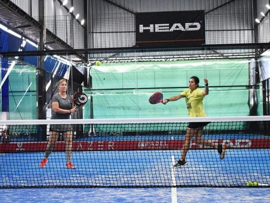 Duas atletas segurando raquete em quadra #paratodosverem