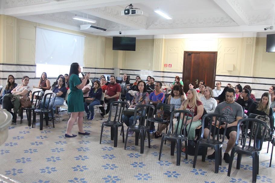 pessoa fala em pé e outras estão sentadas
