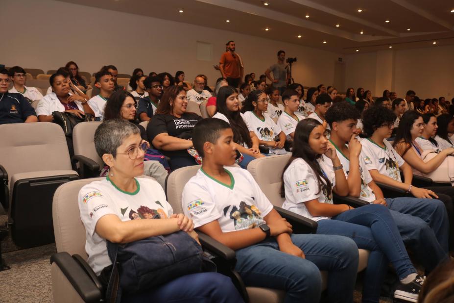 alunos uniformizados sentados em auditório. #paratodosverem 