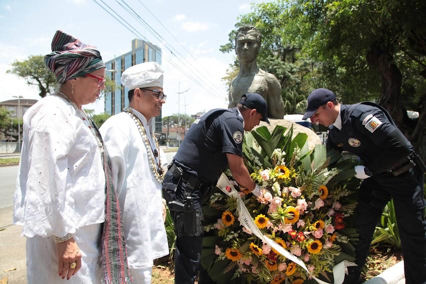 Deposição de flores no busto de Zumbi por dois guardas municipais. #paratodosverem