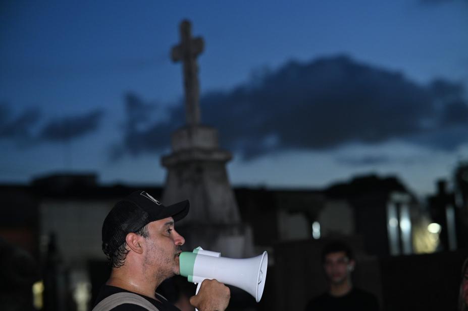 homem com megafone em cemitério à noite. #paratodosverem