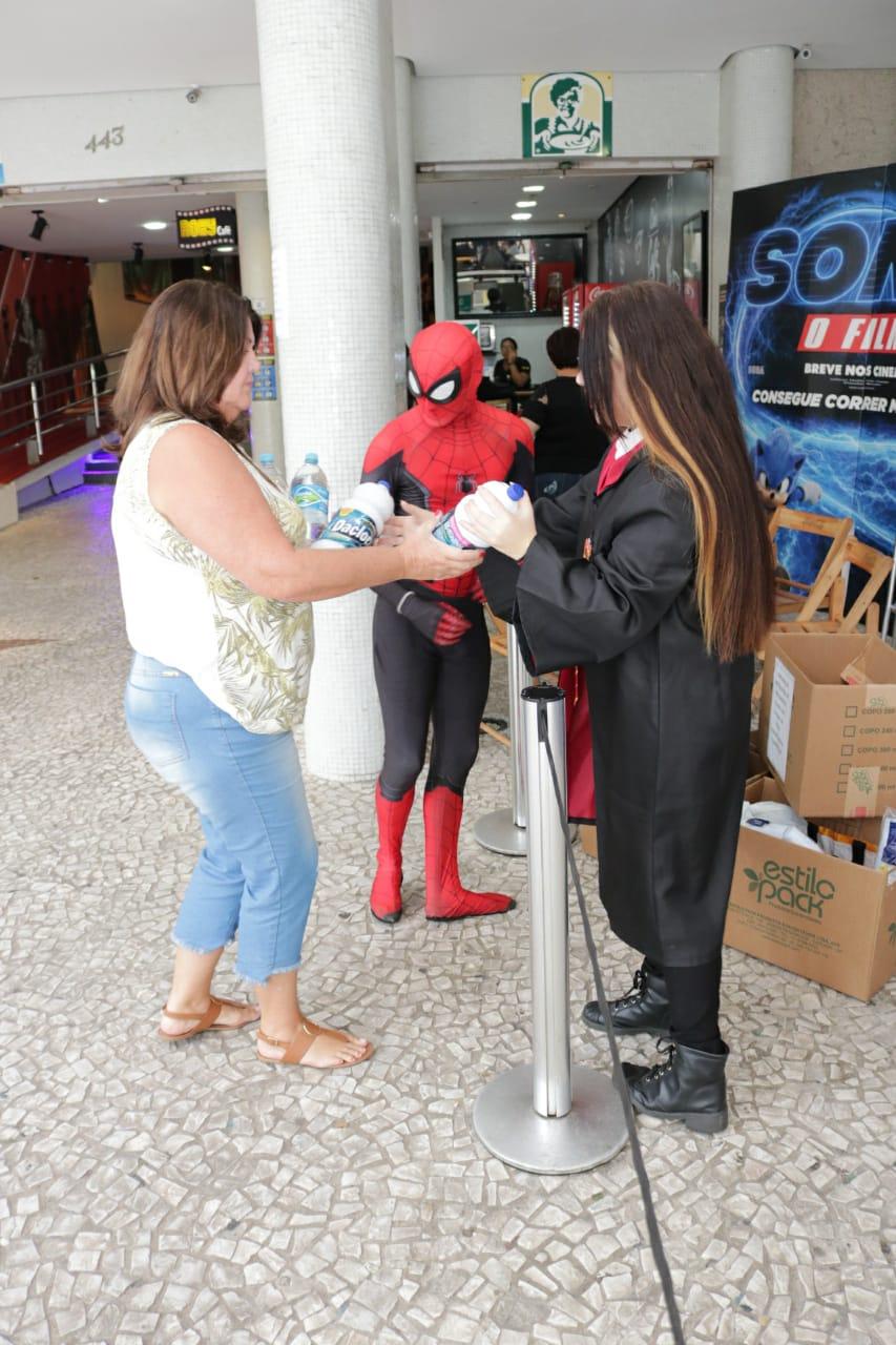 Mulher entrega garrafas de água para Homem Aranha e personagem de Harry Potter.