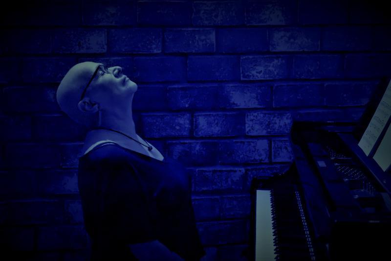 Mulher olhando para cima sentada em frente a piano. #paratodosverem