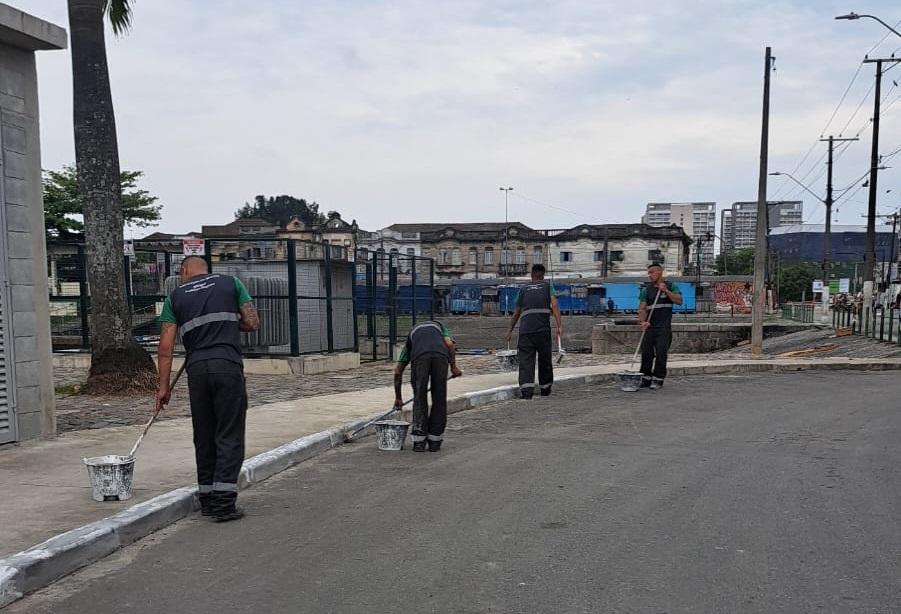 operários realizando pintura em guias #paratodosverem 