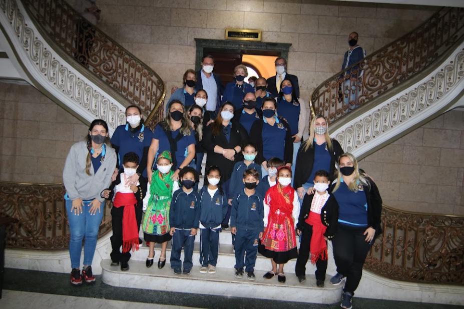 Alunos, autoridades e educadores posam para foto na escadaria do saguão da prefeitura. #paratodosverem