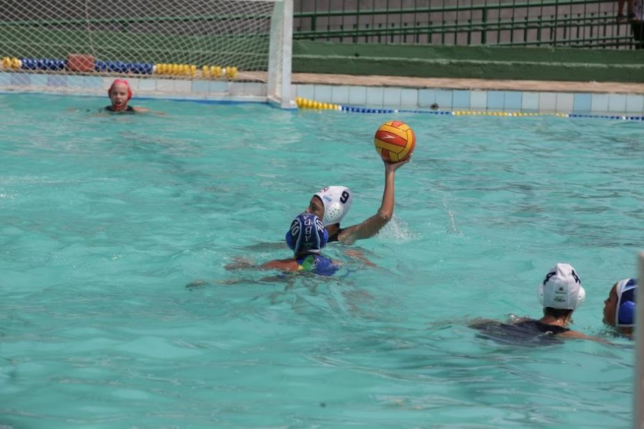 Crianças na piscina jogando polo aquático #paratodosverem