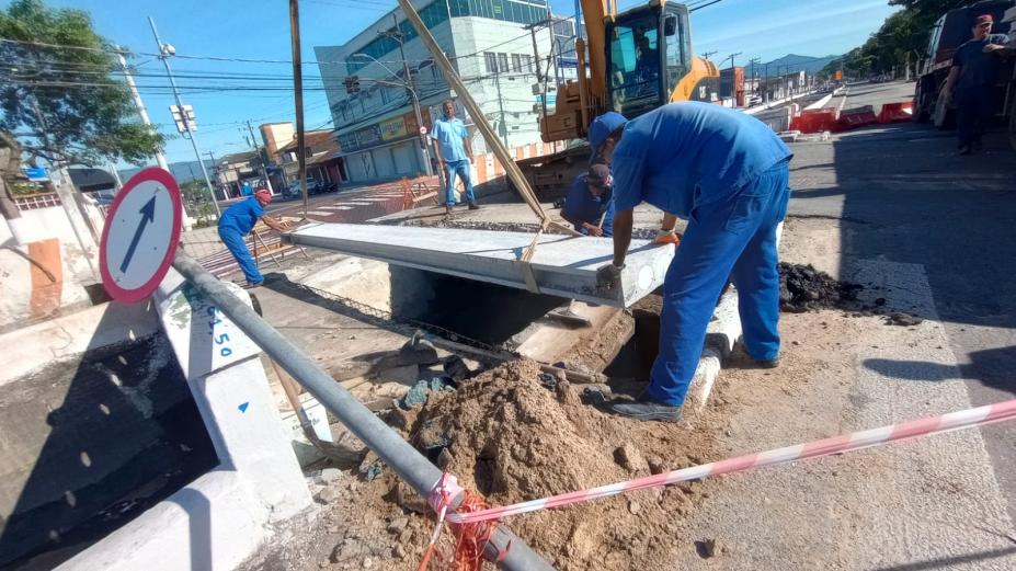 homens encaixam laje em vão de canal. #paratodosverem 