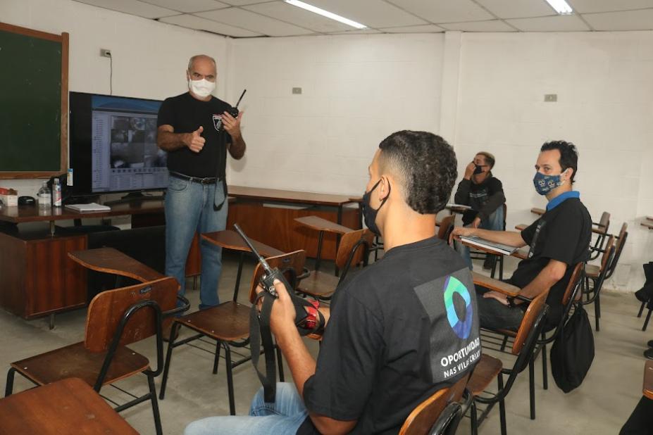 Professor e alunos segurando rádio durante o curso. #paratodosverem