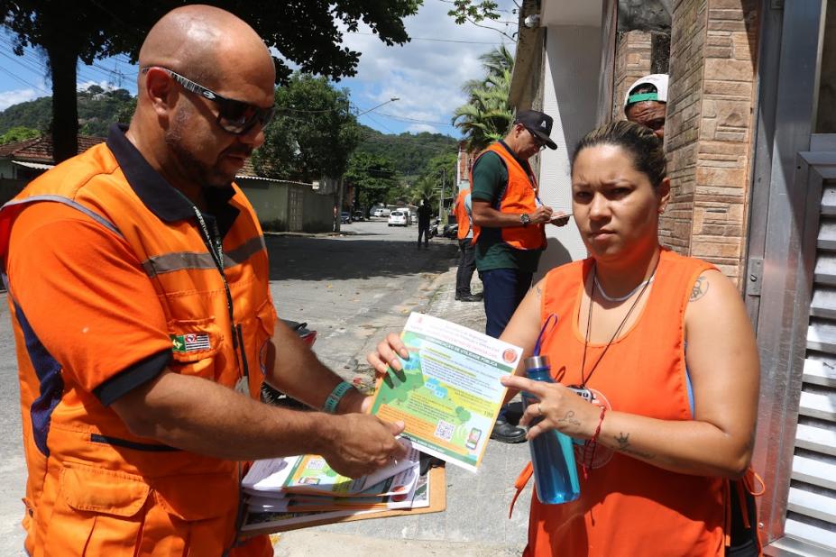 agente da defesa civil entrega panfleto a mulher #paratodosverem
