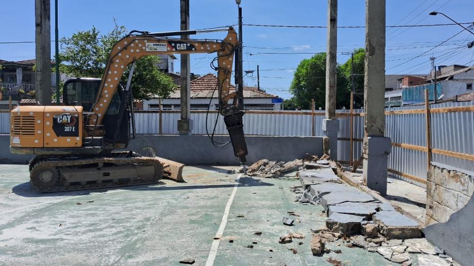 escavadeira quebra piso antigo Ela está dentro de área tapumada