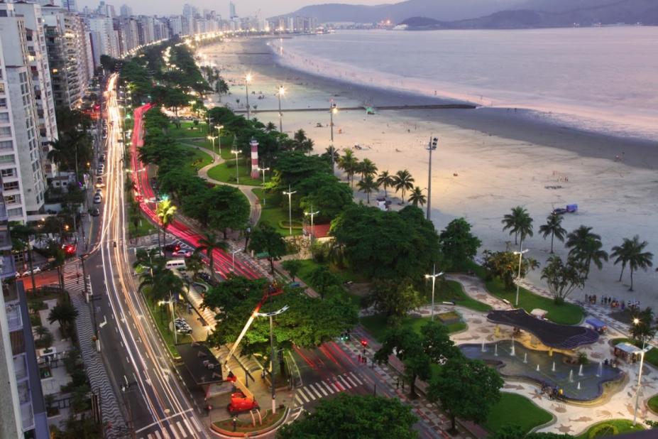 Foto área da praia de Santos aparecendo mar, faixa de areia, jardins e avenida #paratodosverem