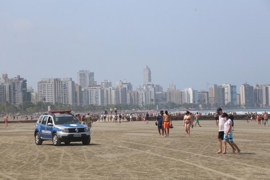 Viatura da guarda municipal na faixa de areia. pessoas estão caminhando. #Paratodosverem