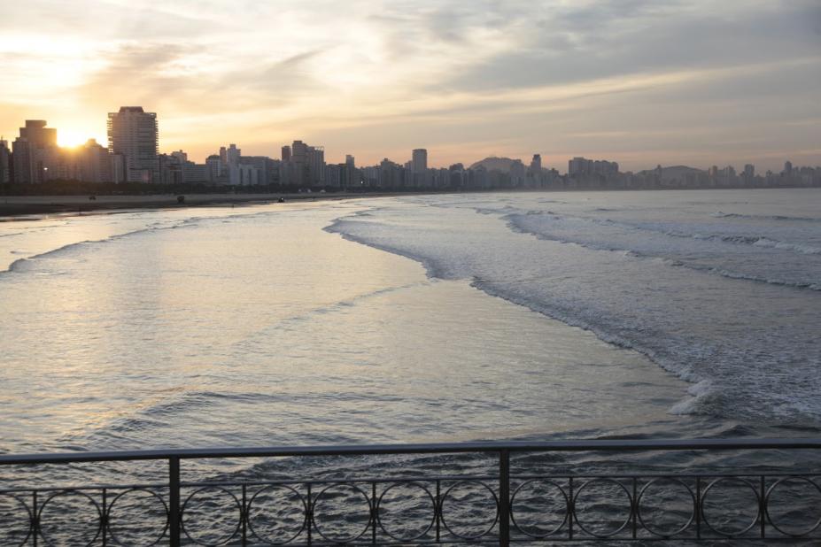 Vista geral do mar em Santos. Em primeiro plano, na parte de baixo, um pedaço da mureta em aço no canal junto ao mar. #Paratodosverem