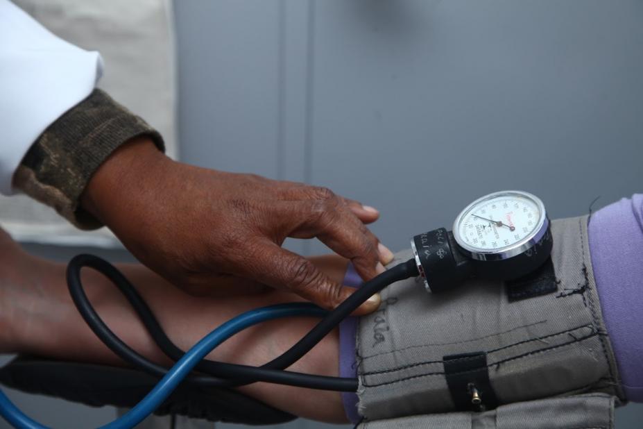 imagem em close de pessoa tendo a pressão arterial medida por outra. #paratodosverem