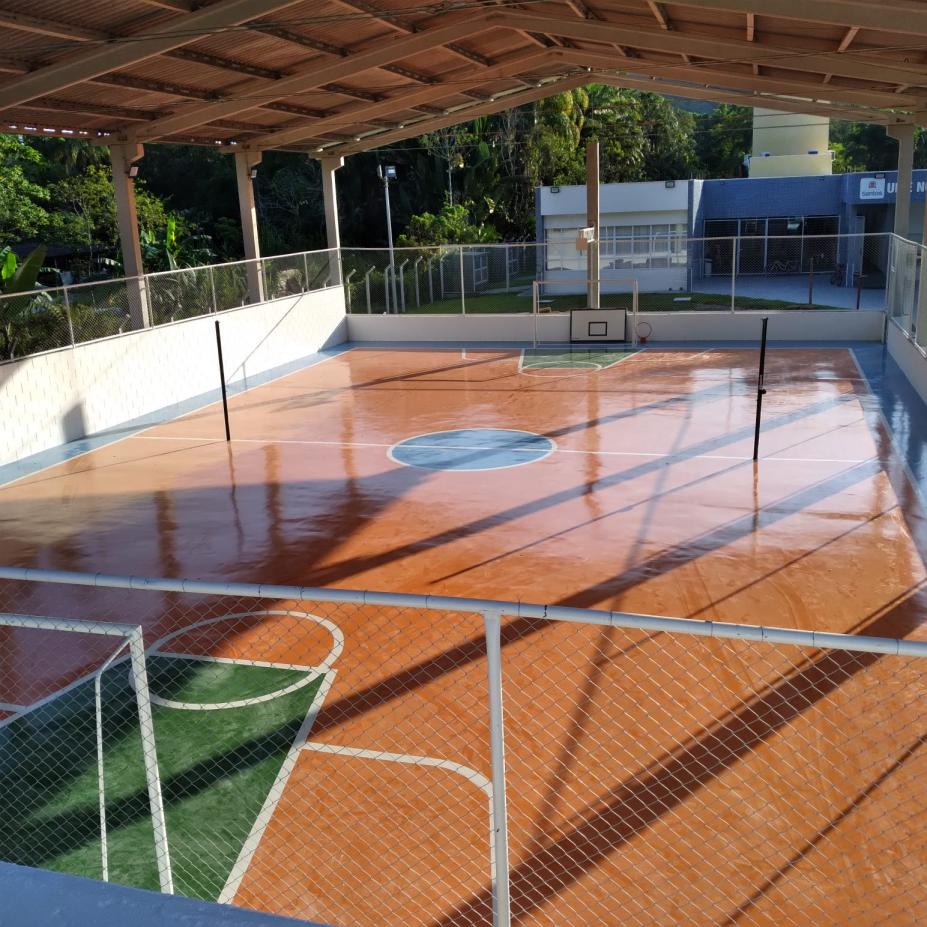 Imagem da nova quadra de esportes vazia, pintada, com marcações e traves. #pratodosverem  