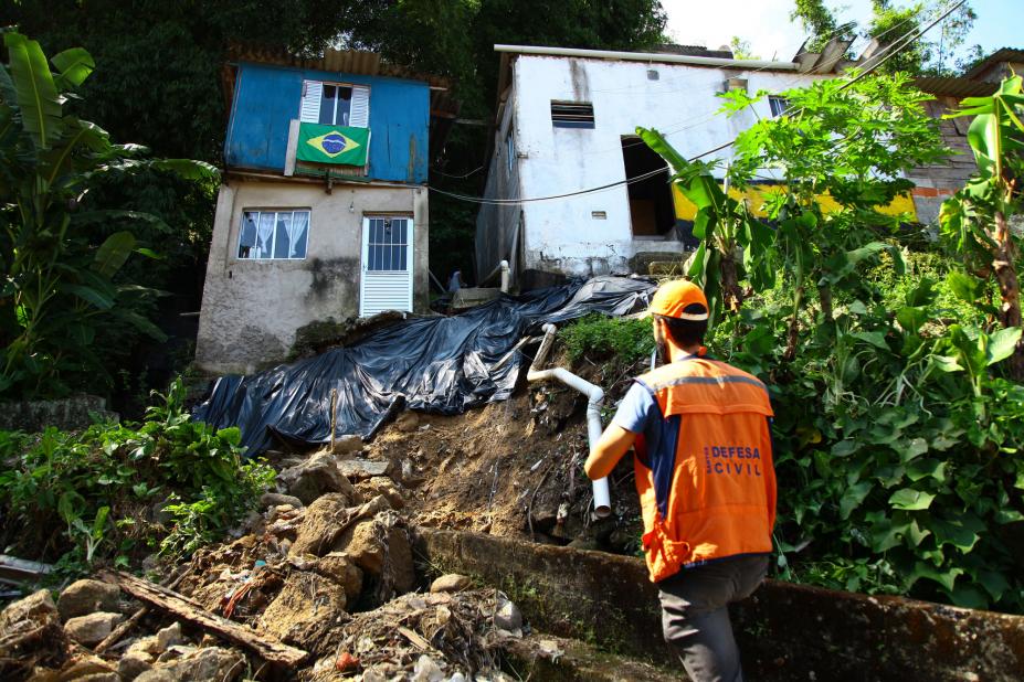 Técnico da defesa civil observa moradia em morro #pracegover