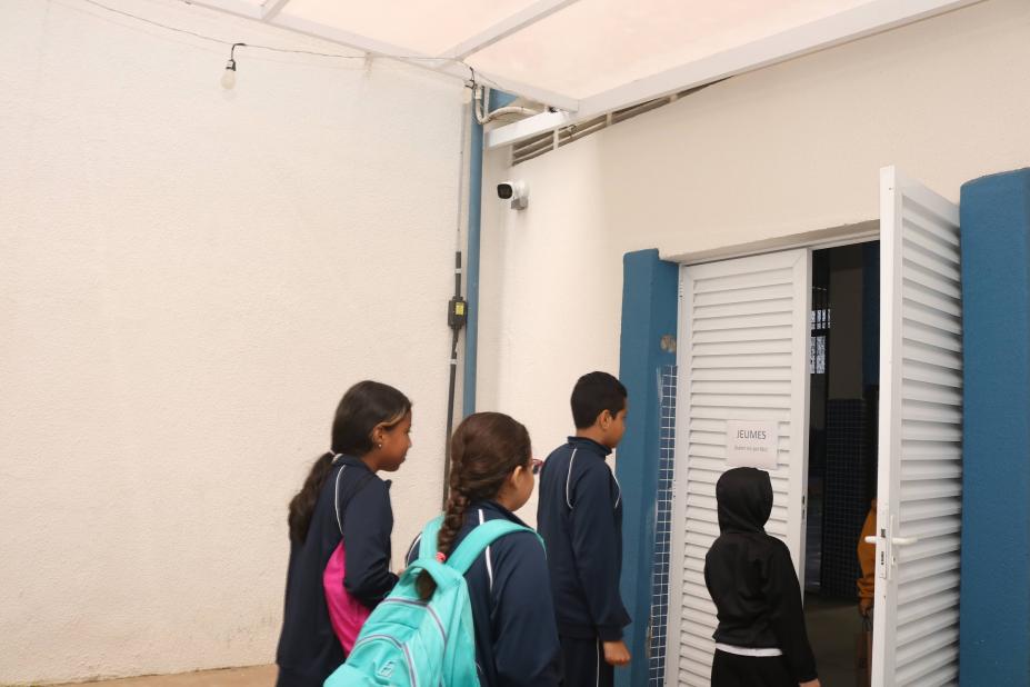 alunos entram em sala. no alto da parede há uma câmera. #paratodosverem