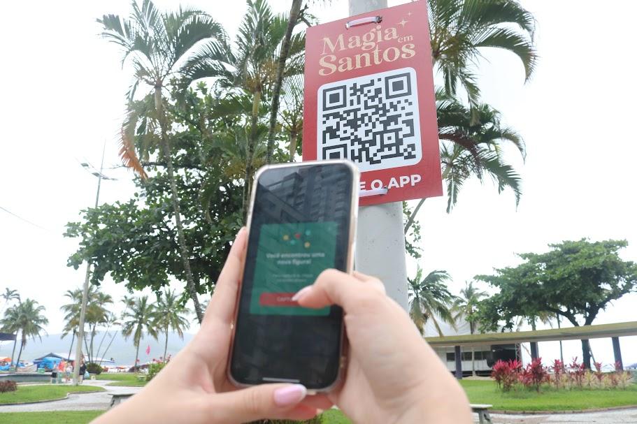 pessoa aponta celular para poste com QR code #paratodosverem