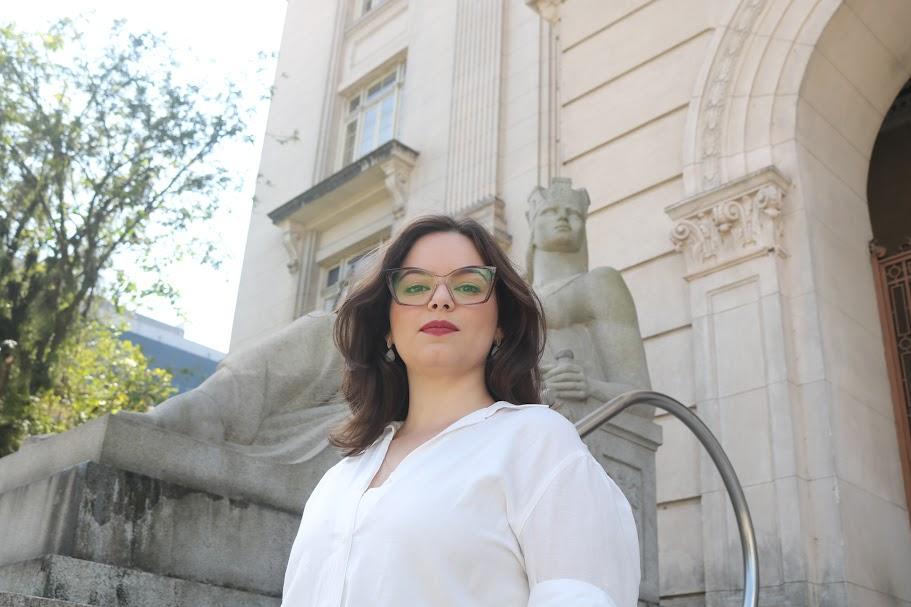 mulher posando em frente a um prédio #paratodosverem