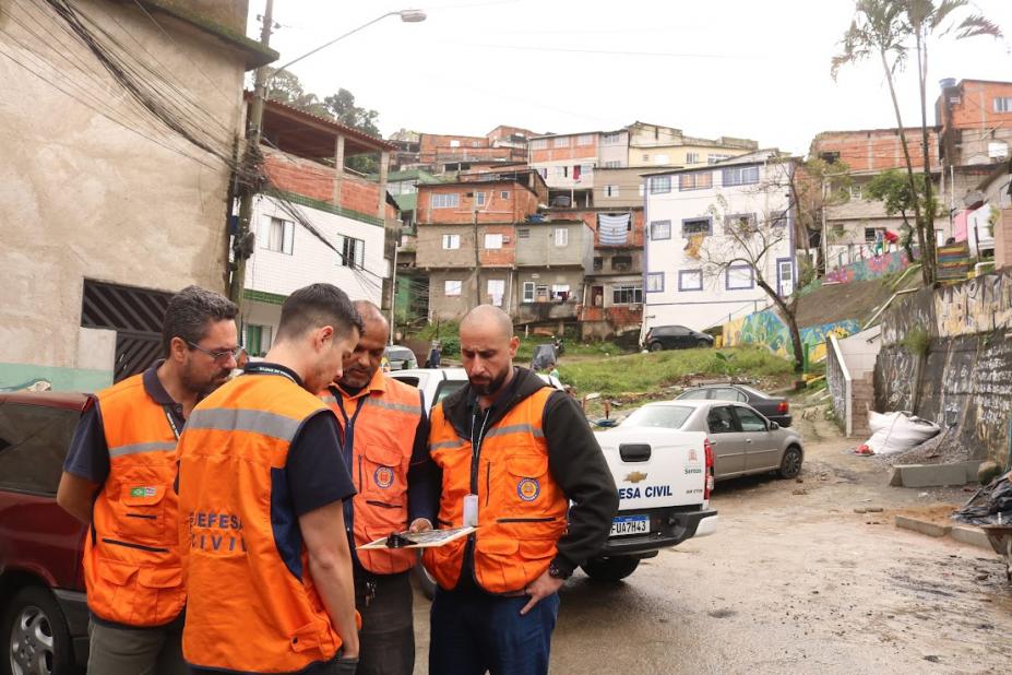 Agentes da defesa civil reunidos em comunidade #paratodosverem