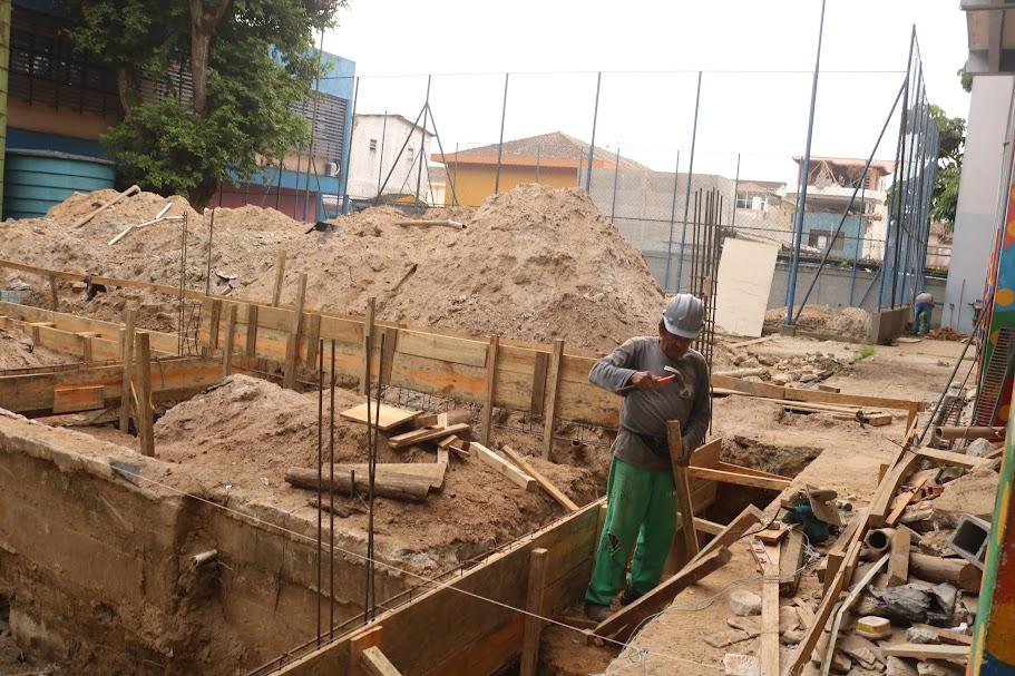 fundação de terreno para construção de prédio. Homem está trabalhando na armação de madeira subterranea. #paratodosverem 