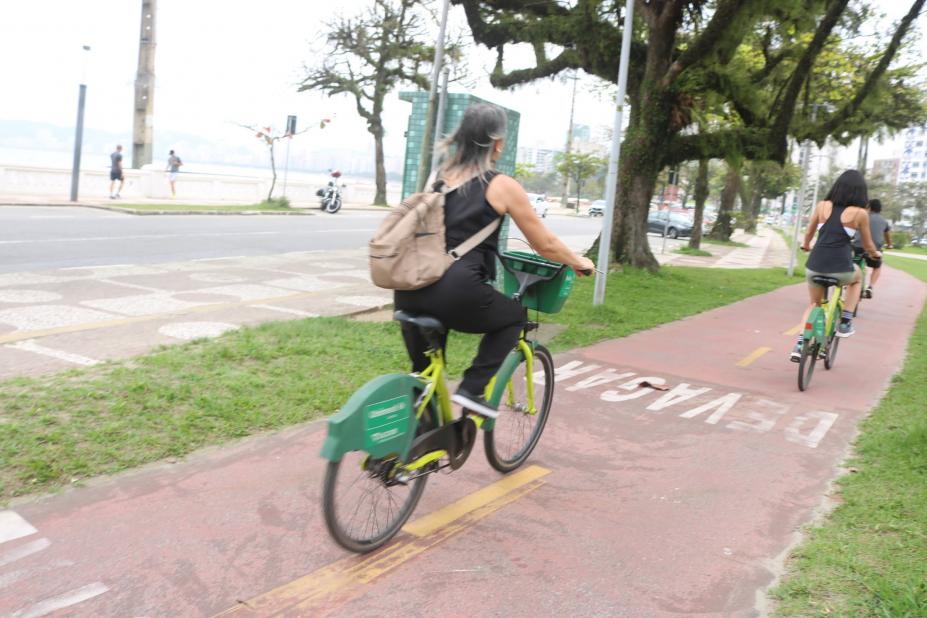 mulher pedala bicicleta do bike santos em ciclovia da orla. #paratodosverem 