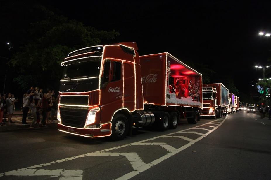 caminhões decorados com luzes natalinas percorrem avenida. #paratodosverem