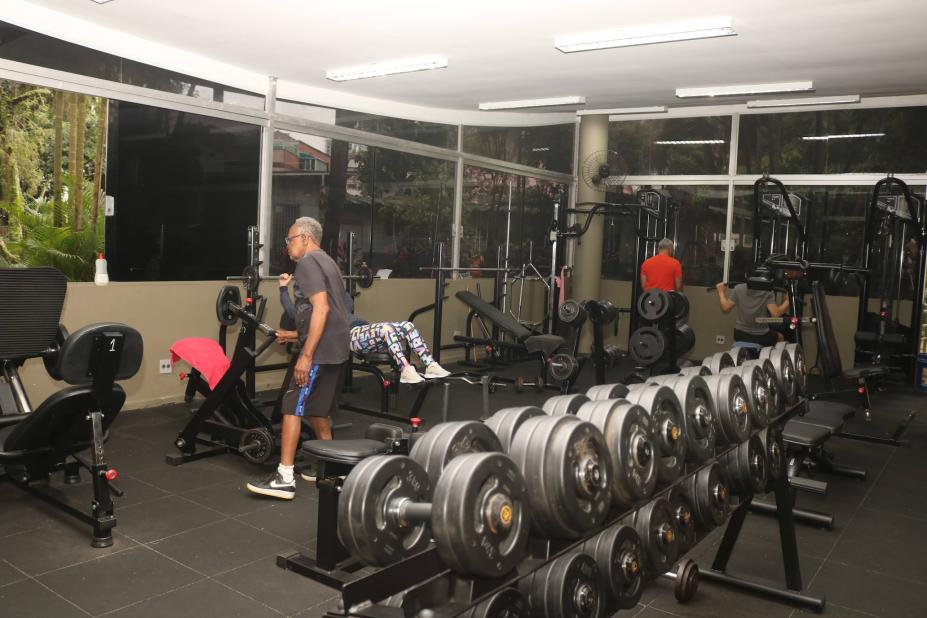sala de musculação com pessoas se movimentando. #paratodosverem