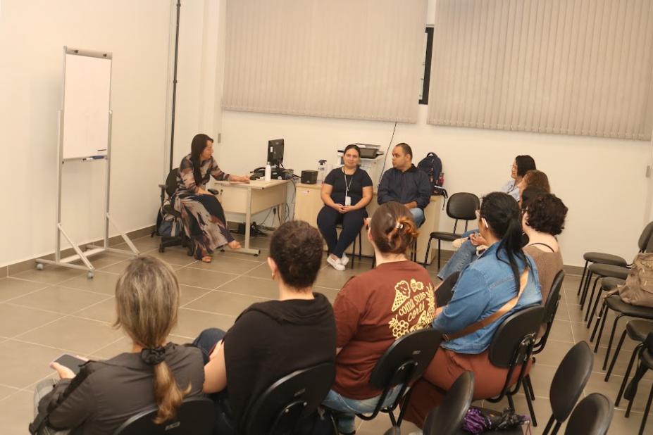 pessoas reunidas em sala, sentadas e conversando. #paratodosverem 