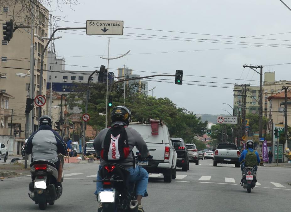 motos paradas em semáforo de avenida. #paratodosverem 