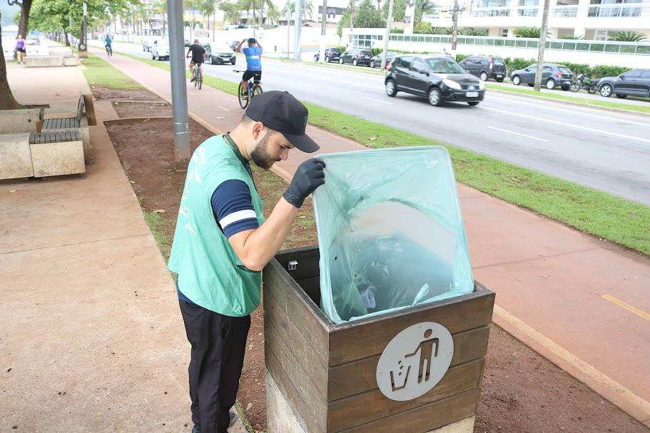 agente usando uniforme vistoria lata de lixo na orla da praia. #paratodosverem 