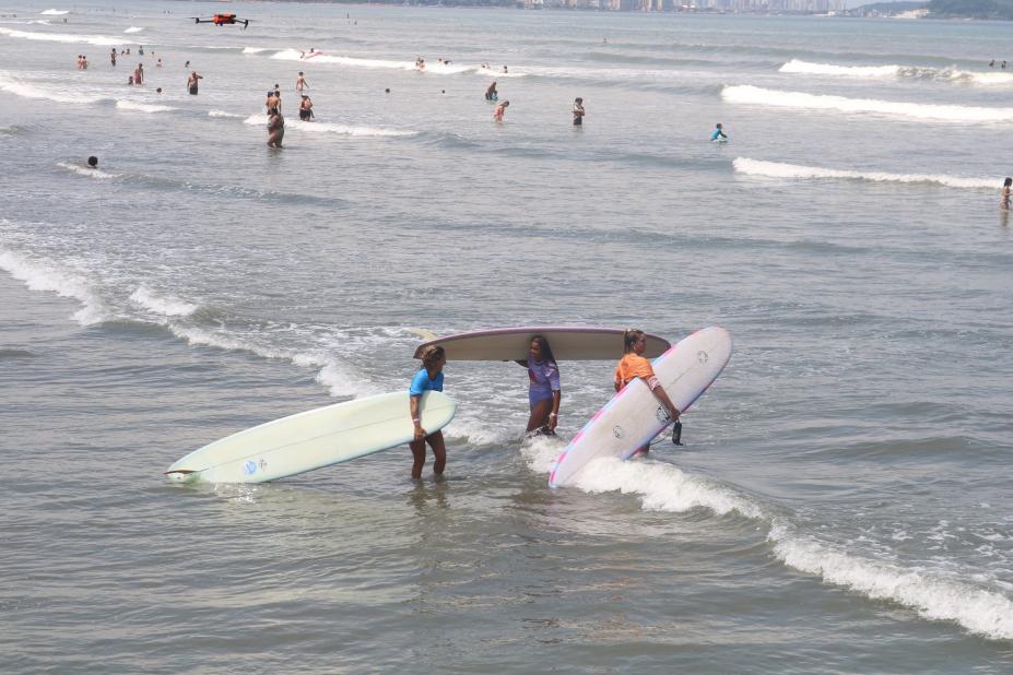 mulheres entram no mar com pranchões. #dparatodosverem